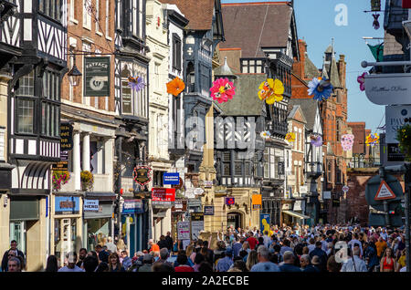 Iconic Eastgate Street in Chester mit traditionellen Tudor Stil Häuser, High Street mit ihren Geschäften und eine Menge Leute spazieren. Stockfoto