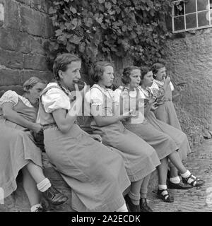 BdM Mädel bei einer Pause mit einem Butterbrot im Landjahr Lager Polle an der Weser, Deutschland 1930er Jahre. BdM-Mädchen, die einen Bruch mit Brot und Butter im Camp in Polle, Deutschland 1930. Stockfoto