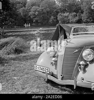 Mit dem Ford V8 unterwegs bin Siehe zum Zelten, Deutschland 1930er Jahre. Mit einem Ford V8 am Ufer eines Sees und ein Zelt, Deutschland 1930. Stockfoto