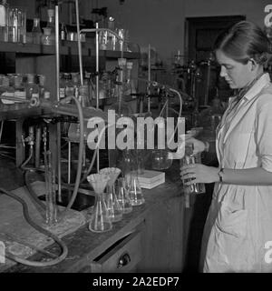 24 Stunden Reportage: Betrieb im Fischereihafen Wesermünde - Lebensmittelchemikerin bei der Analyse, Deutschland 1930er Jahre. 24 Stunden Berichterstattung live von Fischereihafen Wesermuende-lebensmittelchemikerin Analyse in Ihrem Labor, Deutschland 1930. Stockfoto