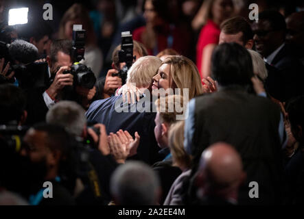 Manchester, Großbritannien. 2. Okt, 2019. Naturschützer Carrie Symonds umarmt ihren Partner und der britische Premierminister Boris Johnson nach seiner Rede am Tag vier von dem Parteitag der Konservativen in Manchester. Quelle: Russell Hart/Alamy leben Nachrichten Stockfoto