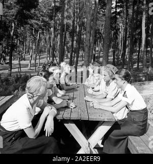 Eine BDM Mädelschaft sitzt in der Sonne im freizeitlager Altenhof am Werbellinsee, Brandenburg, 1930er Jahre. Eine Gruppe von BDM-Mädchen, in der Sonne zu sitzen in der Freizeit Camp der Deutschen Arbeitsfront in Altenhof, Brandenburg, 1930. Stockfoto