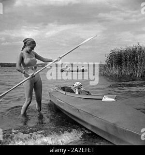 Werbefoto für KLEPPER Faltboot: eine junge Frau mit einem Welpen eine Einems Sehen, Deutschland 1930er Jahre. Werbung für ein Klepper foldboat: eine junge Frau mit einem Welpen an einem See, Deutschland 1930. Stockfoto