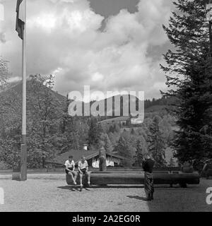 Zwei Jungen lassen sich im Hof der Adolf Hitler die Jugendherberge in Berchtesgaden vor dem Bergpanorama/, Deutschland 1930er Jahre. Ein Junge ein Bild von zwei anderen Jungen vor der Bergkette am Hof des Adolf Hitler Youth Hostel in Berchtesgaden, Deutschland 1930. Stockfoto