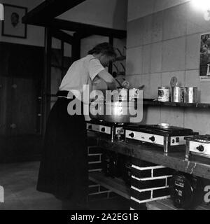 Eine Köchin bereitet eine Bohnensuppe in der Küche der Adolf-Hitler-Jugendherberge in Berchtesgaden, Deutschland 1930er Jahre. Eine Frau Koch bereitet eine Suppe aus Bohnen in der Küche des Adolf Hitler die Jugendherberge in Berchtesgaden, Deutschland 1930. Stockfoto