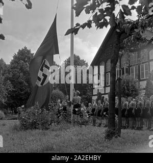 Morgendlicher Fahnenappell im Jungen Landjahr Lager in Bevensen in der Lüneburger Heide, Deutschland 1930er Jahre. Morgendliche flag Muster bei der Hitler Jugend Camp in Bevensen, Deutschland 1930. Stockfoto