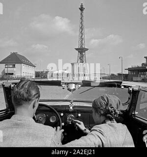 Das telefunken Auto Super Autoradio im Armaturenbrett eines Cabrios, vor dem Funkturm in Berlin, Deutschland, 1930er Jahre. Der Telefunken Auto Super Auto radio an einem Auto Armaturenbrett, vor dem Berliner Funkturm, Deutschland 1930. Stockfoto