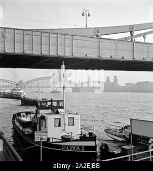 Blick auf die rechte Rheinseite von Köln unter der Hindenburgbrücke am Rhein mit Blick zur Hohenzollernbrücke und den Messeturm, 1930 er Stockfoto