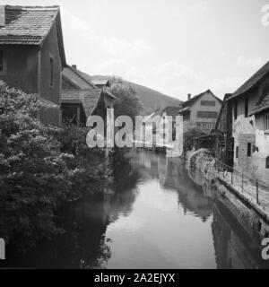 Häuser ein einem Flußlauf in Amorbach im Odenwald, Deutschland 1930er Jahre. Häuser am Ufer des Flusses in Amorbach im Odenwald, Deutschland 1930. Stockfoto