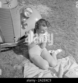 Eine Frau Beim Picknick Vor Einem Ford V6, 1930er Jahre Deutschland. Eine junge Frau, die einen Picknick vor der ein Ford V8, Deutschland der 1930er Jahre. Stockfoto