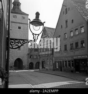 Blick in die ellinger Straße Am Ellinger Tor mit dem Fahrradgeschäft von Georg Frey in Weißenburg, Deutschland 1930er Jahre. Blick auf Ellinger Straße Straße mit Ellinger Tor und Georg Frey's Bicycle store in Weissenburg, Deutschland 1930. Stockfoto