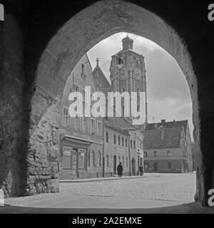 Das Münster Hotel Zur Schönen Unserer Lieben Frau durch einen Torbogen gesehen in Ingolstadt, Deutschland 1930er Jahre. Münster "Unserer Lieben Frau" in Ingolstadt, durch einen Torbogen sehen, Deutschland 1930. Stockfoto