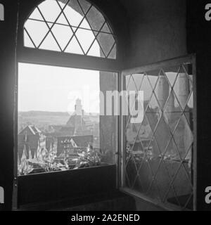 Blick aus einem Fenster in die Stadt und das Münster St. Georg in Dinkelsbühl, Deutschland 1930er Jahre. Blick aus dem Fenster auf die Stadt und den St. George's Münster zu Dinkelsbühl, Deutschland 1930. Stockfoto