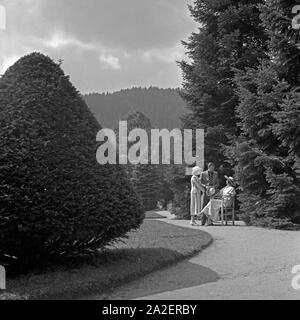 Ein Mann und zwei Frauen in einem Park in Wildbad im Schwarzwald, Deutschland 1930er Jahre. Ein Mann mit zwei Frauen in einem Park in Wildbad im Schwarzwald, Deutschland, 1930. Stockfoto