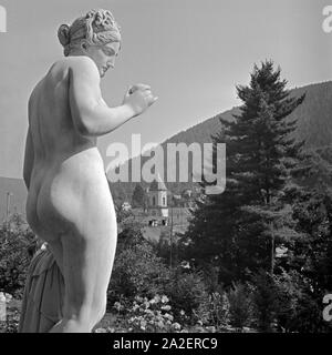 Frauenstatue der Stadtansicht von Wildbad im Schwarzwald, Deutschland 1930er Jahre. Skulptur einer Frau vor der Stadt Wildbad im Schwarzwald, Deutschland der 1930er Jahre. Stockfoto