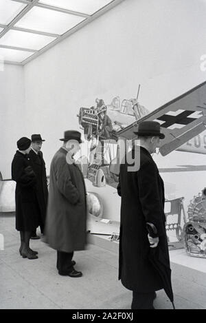 Besucher der Wiener Modewoche, im Haus der Modus "Palais Lobkowitz", betrachten Ausstellungsstücke der Luftfahrttechnik, Deutschland 1940er Jahre. Visi Stockfoto