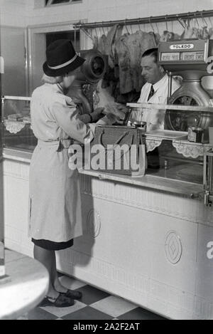 Eine Kundin beim Einkauf im Musterbetrieb Wilhelm Plum in München Gladbach, Deutsches Reich 1941. Ein client Shopping in der Modellpflanze Wilhelm Plum in Stockfoto