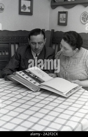 Die Inhaber des Musterbetriebs Wilhelm Pflaume mit einem Fotoalbum, Deutsches Reich 1941. Eigentümer der Modellpflanze Wilhelm Pflaume mit einem Fotoalbum, Deutschland 1941. Stockfoto