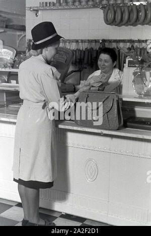 Eine Kundin beim Einkauf im Musterbetrieb Wilhelm Plum in München Gladbach, Deutsches Reich 1941. Ein client Shopping in der Modellpflanze Wilhelm Plum in Stockfoto