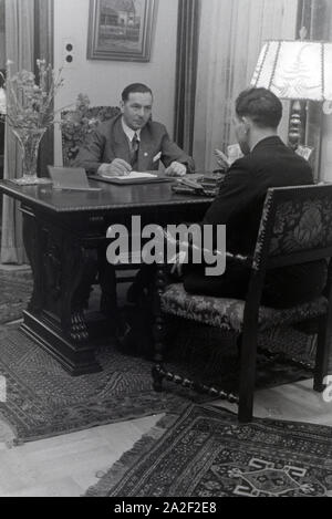 Der Inhaber des Musterbetriebs Wilhelm Pflaume mit einem Geschäftspartner, Deutsches Reich 1941. Eigentümer der Modellpflanze Wilhelm Pflaume mit einem Business Partner, Deutschland 1941. Stockfoto