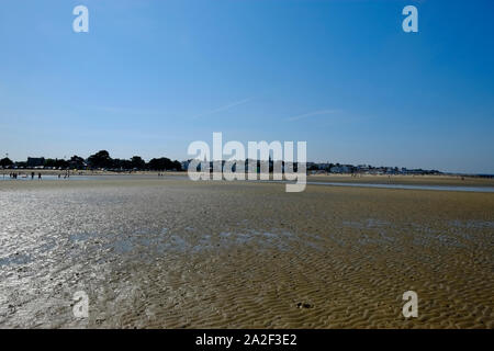 Strand goers in der Ferne auf Ryde Sandbänken bei Ebbe mit Blick auf die Stadt von Ryde Stockfoto