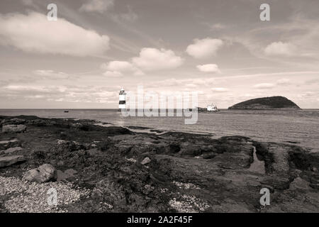 Der östliche Endpunkt von Anglesea, die die Passage zwischen dem Ufer und Papageitaucher Insel mit Leuchtturm Penmon Stockfoto