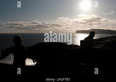 Die surfbretter auf ihren Köpfen surfer Kopf in Silhouette über die Klippen in Compton Chine auf der Isle of Wight Stockfoto