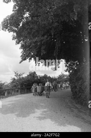 Eine Schulklasse auf einem Wanderausflug im Stuttgarter Umland, allen voran der Lederhosen tragende Lehrer, Deutschland 1930er Jahre. Eine Schulklasse auf eine Wanderung im Stuttgarter Umland, mit der Lehrer in Lederhosen die Weise führen, Deutschland 1930. Stockfoto