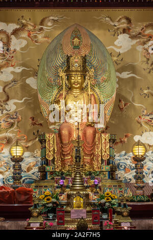 Singapur - März 22, 2019: Buddha Zahns Tempel in Chinatown. Nahaufnahme der Medizin Buddha. Gold dominant. Himmel, Dragon Retabel. Geschenke und Blumen Stockfoto