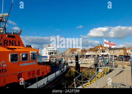 Yarmouth Hafen auf der Isle of Wight mit wightlink Fähren und die rnli Flagge über dem Rettungsboot station Stockfoto