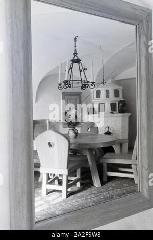 Ansicht vom Esszimmer mit Holzmöbeln und Kamin auf Schloss Hartmannsberg, Residenz von Bildhauer Josef Thorak, Deutschland 1930er Jahre. Blick auf einen Speisesaal mit Holzmöbeln in Hartmannsberg schloss, die Residenz der Bildhauer Josef Thorak, Deutschland 1930. Stockfoto