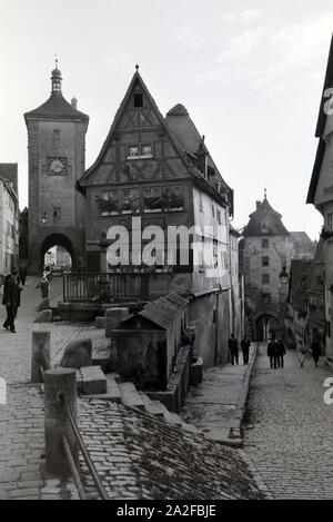 Geschäftiges Treiben auf dem kleinen Plönlein mit dem Sieberstor Koboleller Tor links und rechts, Rothenburg o.d. Tauber, Deutschland 1930er Jahre. Ein reges Treiben auf dem kleinen Platz mit dem siebers Tor auf der linken Seite und die kobolzeller Tor auf der rechten Seite, Rothenburg o.d. Tauber, Deutschland 1930. Stockfoto