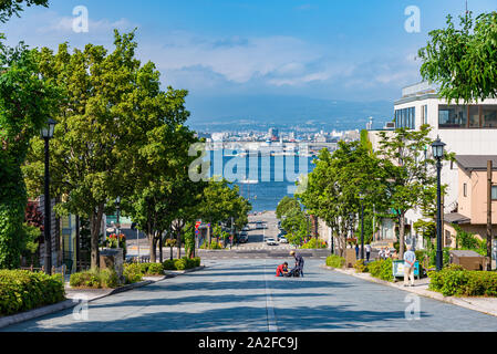 Ansicht des Hachiman-zaka Hang im Sommer sonnigen Tag weiße Wolken und bule Himmel. Eine schräge Street berühmt in Film und Werbung. Beliebte Sehenswürdigkeiten Stockfoto