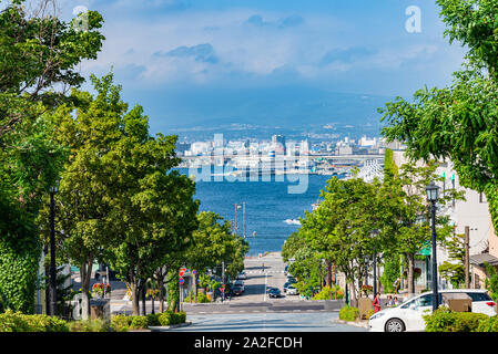 Ansicht des Hachiman-zaka Hang im Sommer sonnigen Tag weiße Wolken und bule Himmel. Eine schräge Street berühmt in Film und Werbung. Beliebte Sehenswürdigkeiten Stockfoto