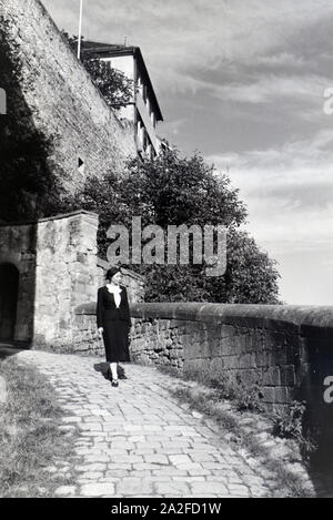 Eine junge Frau genießt den Ausblick vom Schloss Hohentübingen über die Altstadt Tübingens, Deutschland 1930er Jahre. Eine junge Frau enyoing der Panoramablick vom Schloss Hohentübingen über der Altstadt von Tübingen, Deutschland 1930. Stockfoto