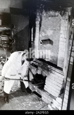 Ein Schüler der Fachschule für Keramik stellt frisch getöpferte Gefäße in den Brennofen, Höhr-Grenzhausen, Deutschland 1930er Jahre. Ein Student der Hochschule für Keramik setzt neu Töpfe in den Brennofen, Höhr-Grenzhausen, Deutschland 1930 fictiled. Stockfoto