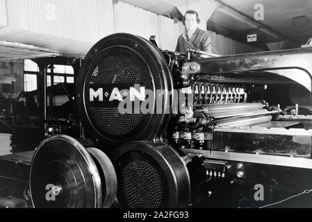 Eine Arbeiterin Rotationsdruckmaschine kontrolliert Sterben in den Werken des Maschinenbaukonzerns MAN (Maschinenfabrik Augsburg-Nürnberg), Deutschland 1930er Jahre. Ein Arbeitnehmer, der die Steuerung der Rotationsdruckmaschine, die in den Anlagen der mechanischen Engineering Company MAN (Maschinenfabrik Augsburg-Nürnberg), Deutschland 1930. Stockfoto