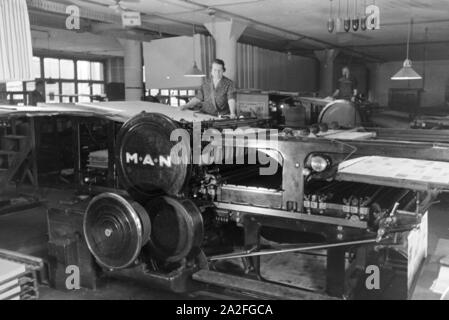 Eine Arbeiterin Rotationsdruckmaschine kontrolliert Sterben in den Werken des Maschinenbaukonzerns MAN (Maschinenfabrik Augsburg-Nürnberg), Deutschland 1930er Jahre. Ein Arbeitnehmer, der die Steuerung der Rotationsdruckmaschine, die in den Anlagen der mechanischen Engineering Company MAN (Maschinenfabrik Augsburg-Nürnberg), Deutschland 1930. Stockfoto