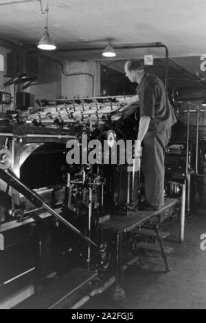 Ein Drucker kontrolliert sterben Rotationsdruckmaschine in den Werken des Maschinenbaukonzerns MAN (Maschinenfabrik Augsburg-Nürnberg), Deutschland 1930er Jahre. Einen Drucker steuern der Rotationsdruckmaschine, die in den Anlagen der mechanischen Engineering Company MAN (Maschinenfabrik Augsburg-Nürnberg), Deutschland 1930. Stockfoto