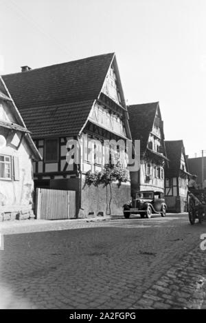 Eine Straße mit Fachwerkhäusern in Bruchsal, Deutschland 1930er Jahre. Eine Straße mit Fachwerkhaus Gebäude in Bruchsal, Deutschland 1930. Stockfoto