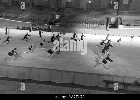 Eine Gruppe der Hitlerjugend beim Training in einem Dortmunder Eisstadion unter der Leitung vom österreichischen Eiskunstläufer und Olympiasieger Karl Schäfer, Deutschland 1930er Jahre. Eine Gruppe von Hitler Jugend Mitglieder während einer Ausbildung, trainiert durch die Österreichische figureskater und Olympiasieger Karl Schäfer in einem Eisstadion in Dortmund, Deutschland 1930. Stockfoto