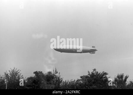 Zeppelin LZ 129 Hindenburg Olympiafahrt bei der über dem Reichssportfeld in Berlin, Deutschland, 1930er Jahre. Zeppeilin Hindenburg LZ 129 auf seiner olympischen Fahrt über Reichssportfeld Sportplatz in Berlin, Deutschland 1930. Stockfoto