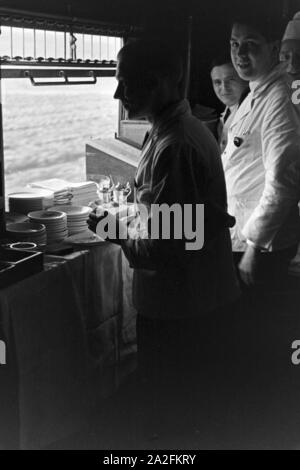 Das Personal der Mitropa in einem Speisewagen der Deutschen Reichsbahn, Deutschland 1930er Jahre. Mitropa Personal an einem Speisewagen der Deutschen Reichsbahn, Deutschland 1930. Stockfoto