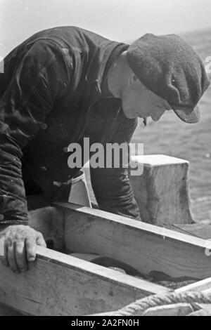 Ein Hochseefischer bei der Arbeit ein Deck, Deutschland 1930er Jahre. Ein tiefes Meer Fischer Arbeiten an Deck, Deutschland 1930. Stockfoto