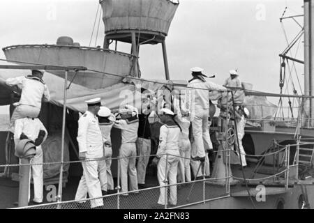 Matrosen bei der Arbeit auf Deck des Schiffs im Hafen Usedom an der Ostsee, Deutschland 1930er Jahre. Segler an Deck eines Schiffes im Usedom Hafen an der Ostsee, Deutschland 1930. Stockfoto