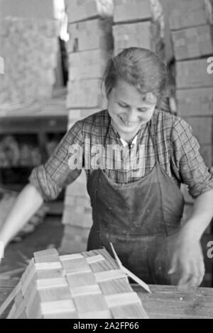 Arbeiterin in der Bühler Spankorbfabrik, sterben sterben sterben Körbe für die Erdbeerernte liefert, Deutschland 1930er Jahre. Arbeiterin in der Fabrik gebäude der Korb Fabrik, die Herstellung der Körbe für die Erdbeere Ernte in Bühl, Deutschland 1930. Stockfoto