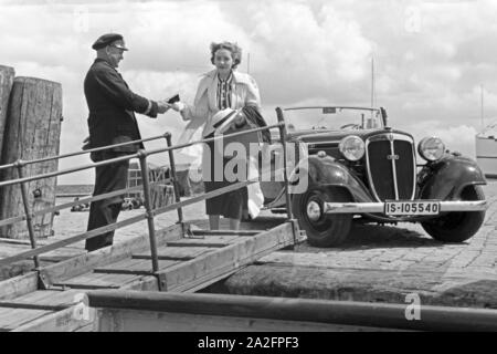 Eine Frau begrüßt einen Seemann an der Gangway in Norddeich Mole vor ihrem Audi Cabrio, Deutschland 1930er Jahre. Eine Frau und ein Seemann die Hände schütteln über einen Gang vor ein Audi Cabrio, Deutschland 1930. Stockfoto