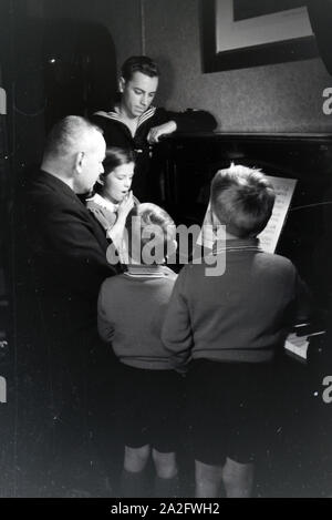 Mitglieder einer kinderreichen Familie beim Klavierspielen, Deutsches Reich 30er Jahre. Mitglieder der Großfamilie, Klavier spielen, Deutschland 1930. Stockfoto