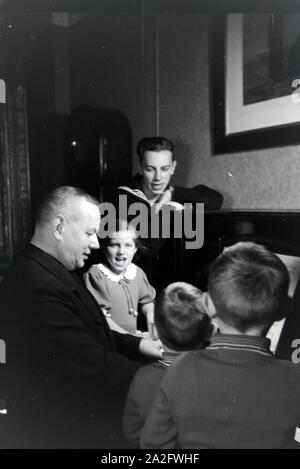 Mitglieder einer kinderreichen Familie beim Klavierspielen, Deutsches Reich 30er Jahre. Mitglieder der Großfamilie, Klavier spielen, Deutschland 1930. Stockfoto