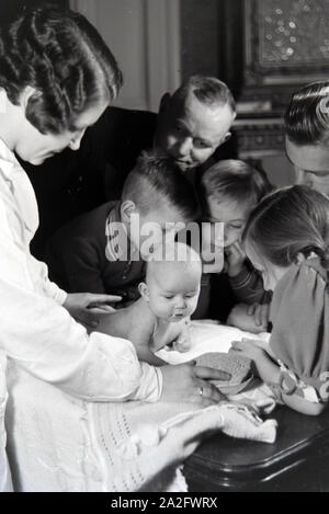 Mitglieder einer kinderreichen Familie mit dem Neugeborenen, Deutsches Reich 30er Jahre. Mitglieder der Großfamilie, mit dem neugeborenen Baby, Deutschland 1930. Stockfoto